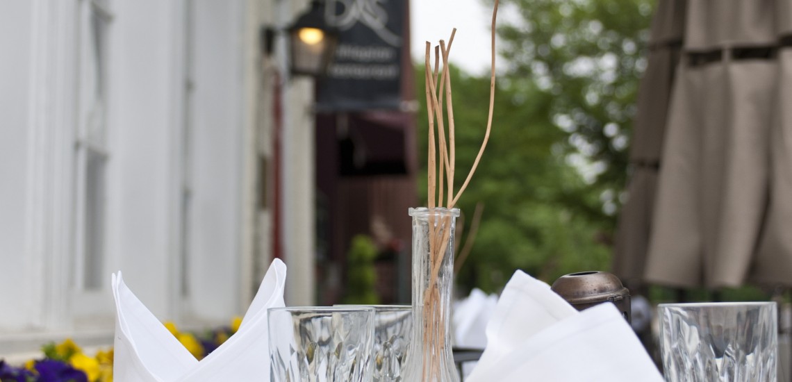 A small vase with a few reed diffuser sticks.