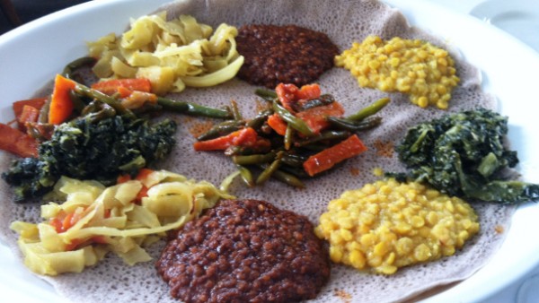 A traditional Ethiopian food platter with various stews and vegetables.
