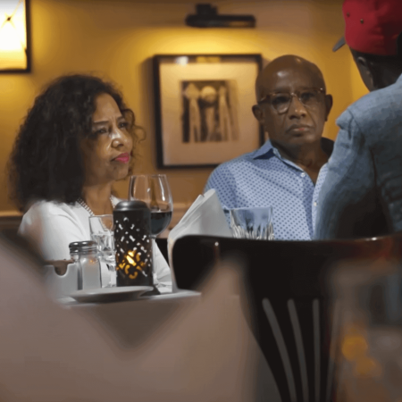 Three people conversing at a restaurant table.